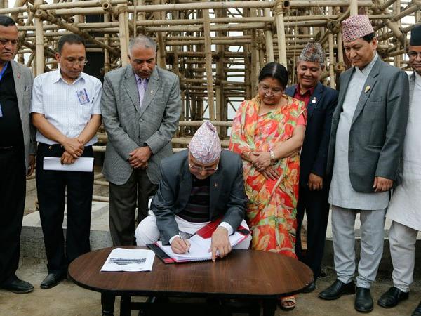 PM Oli writes his remarks in front of the Kasthamandap temple